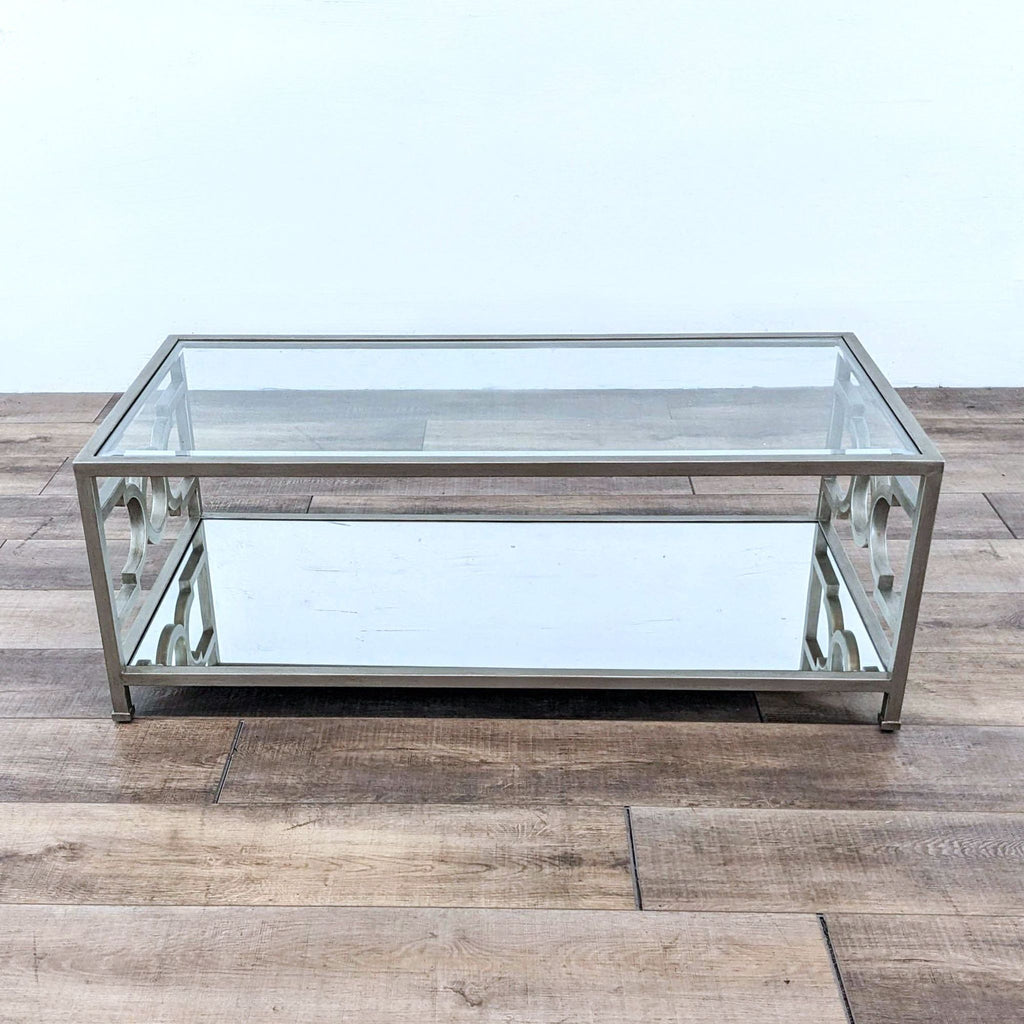 Contemporary Neiman Marcus mirrored coffee table with geometric metal supports, displayed on a hardwood floor.