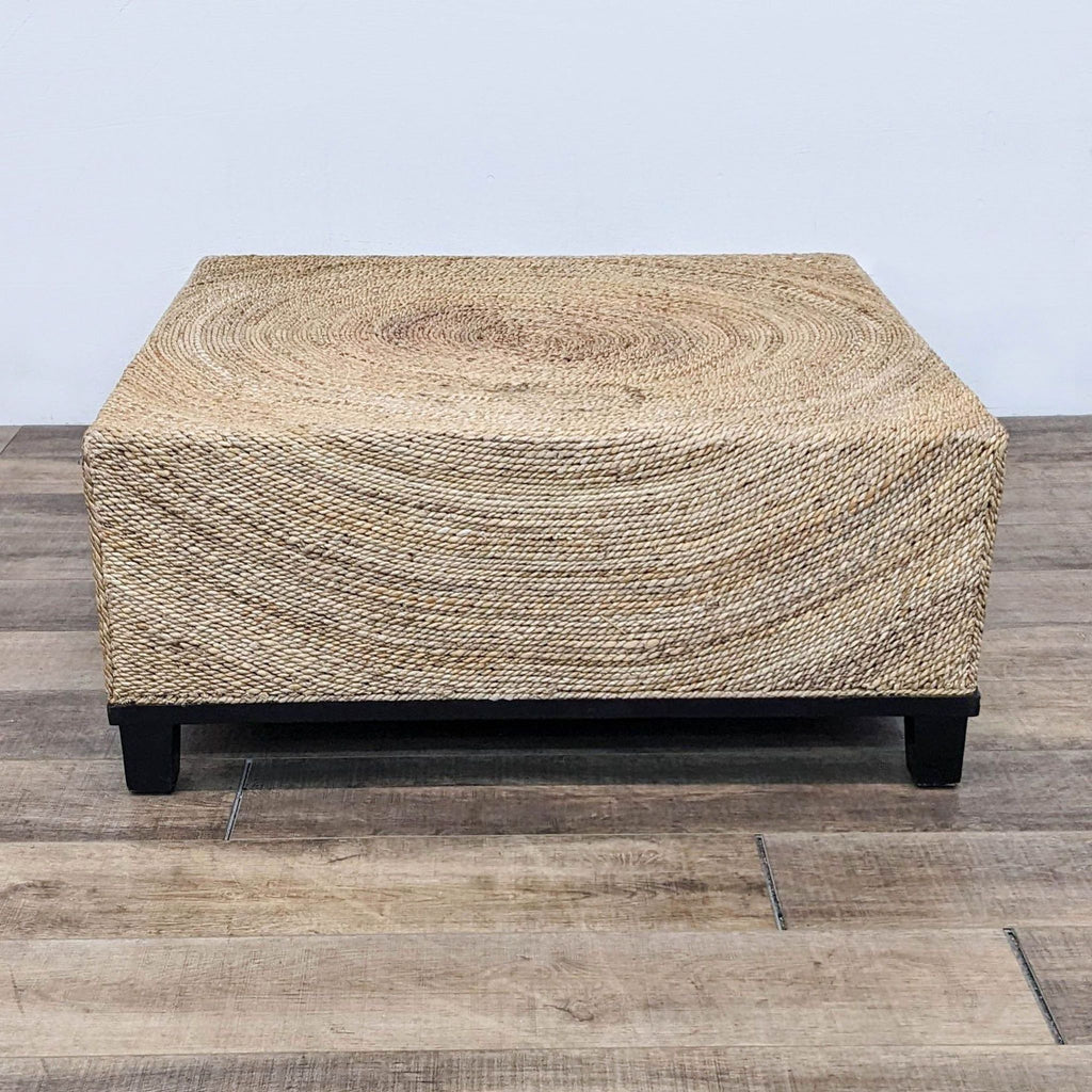 Reperch brand coffee table with natural fiber woven top and black legs on a wooden floor.