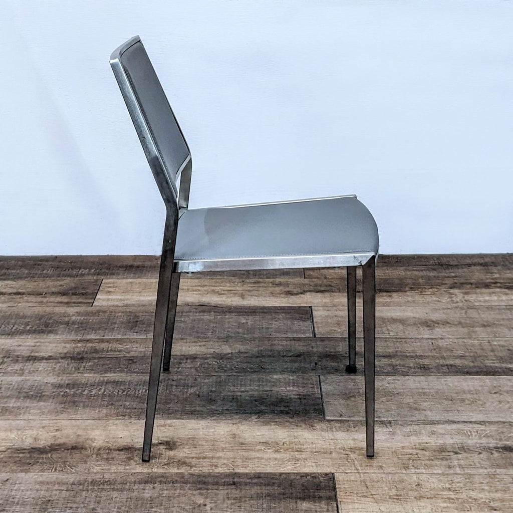 Side view of a contemporary Kinwai Inc dining chair with metallic frame and upholstered seat.