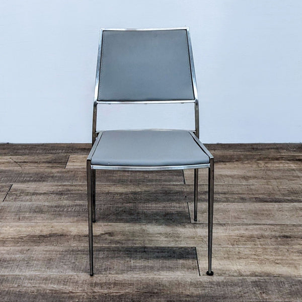 Modern Kinwai Inc dining chair with brushed metal frame and grey faux leather, showcased on wood floor.