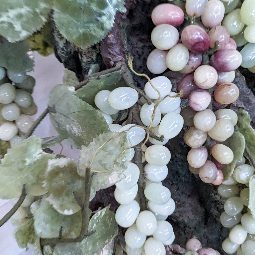 2. Close-up view of artificial grapevine with detailed leaves and grapes in varying shades of green, pink, and purple.