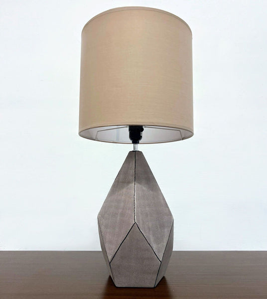 Reperch brand lamp with neutral-toned shade and faceted textured base, unlit.