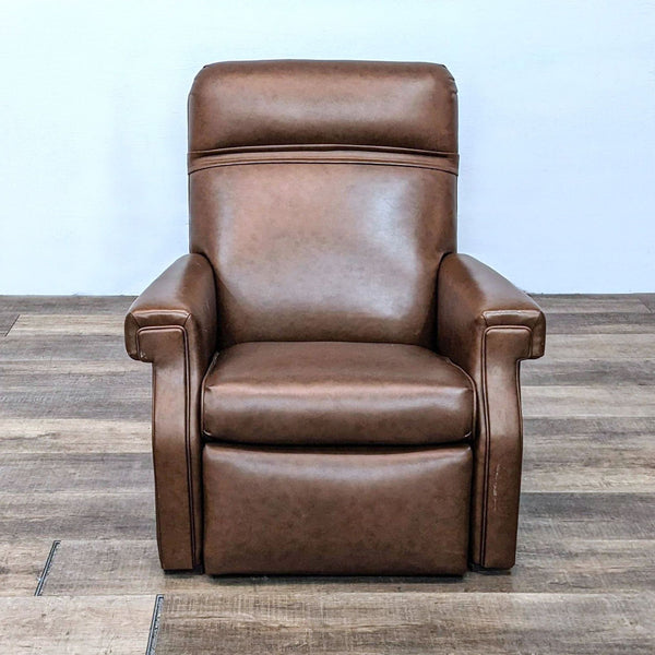 Reperch leather recliner in upright position with nailhead trim on wooden floor.