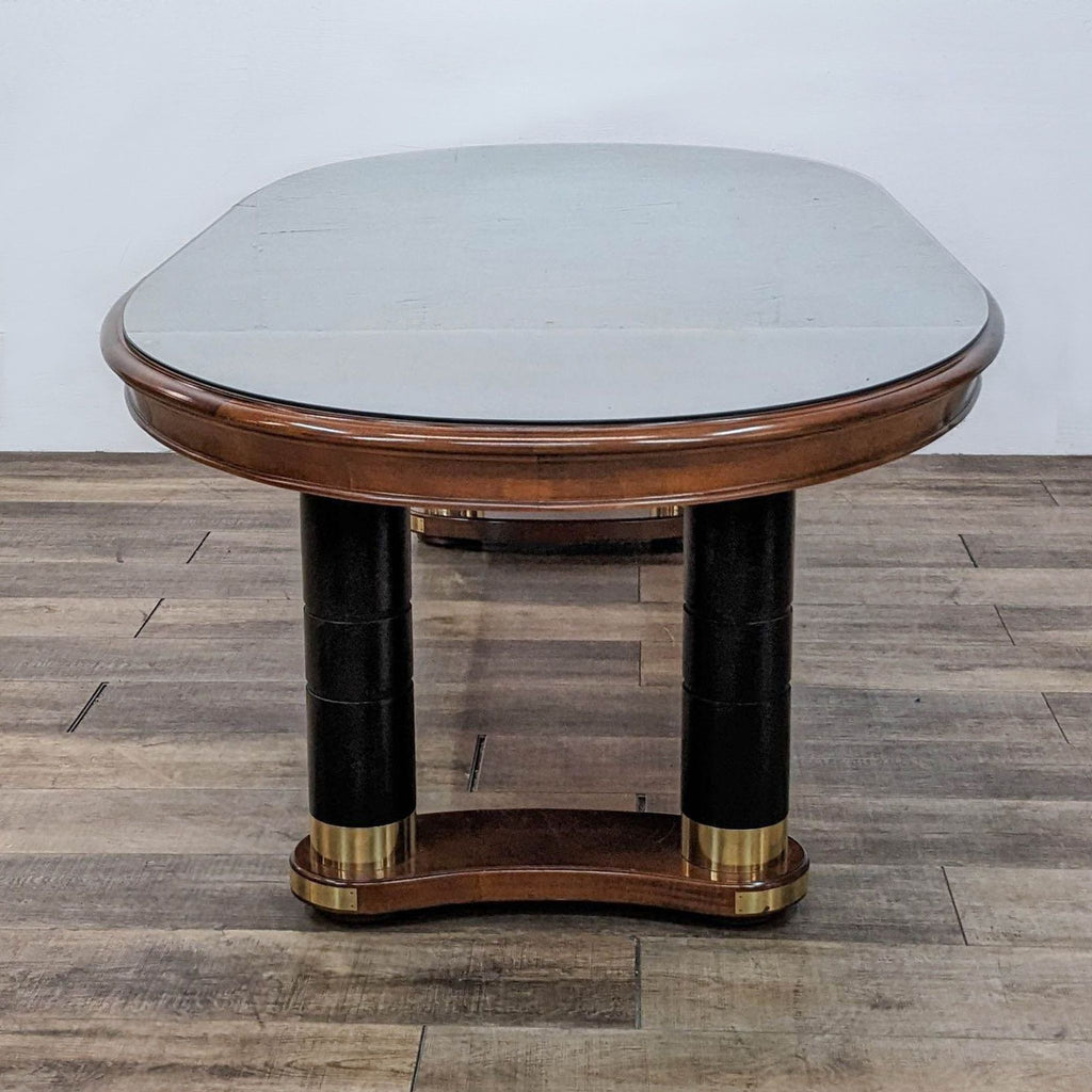 Stanley Furniture cherry table, pictured with two leaves, oval shape, on a double pedestal with brass accents.