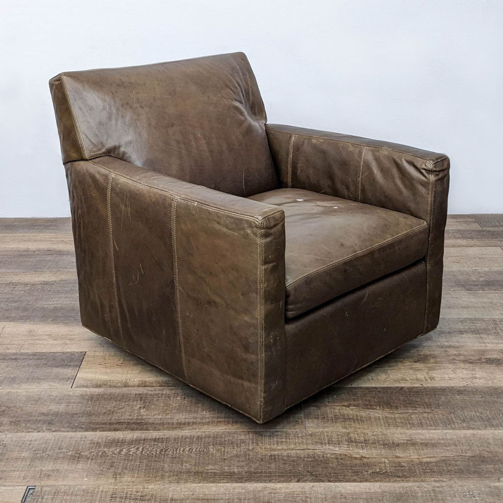Side view of a Crate & Barrel lounge chair, showcasing its brown leather upholstery and minimalist design.