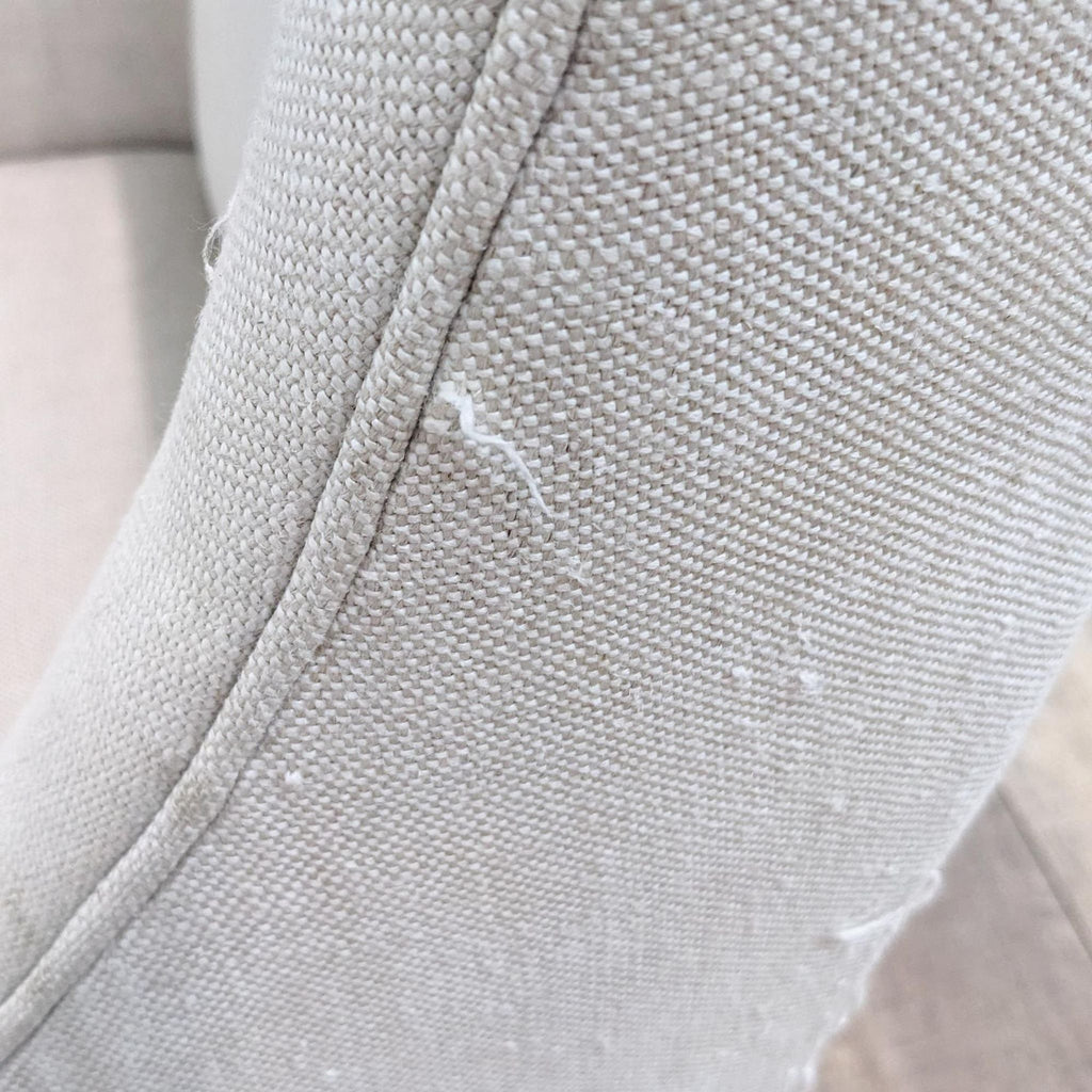 Close-up of beige fabric with minor stains on a Restoration Hardware lounge chair.