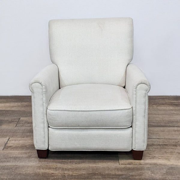 Pottery Barn beige upholstered armchair on a wooden floor, front view.