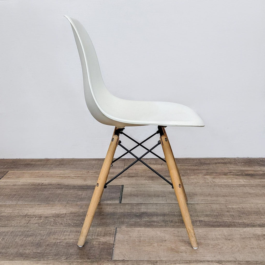 Side view of Reperch contoured white dining chair with wooden legs and metal supports.