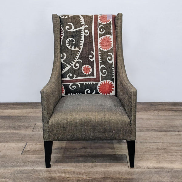 High-backed Pluto chair by Andrew Martin with thick padded seat, patterned backrest, winged arms, in a lounge setting.