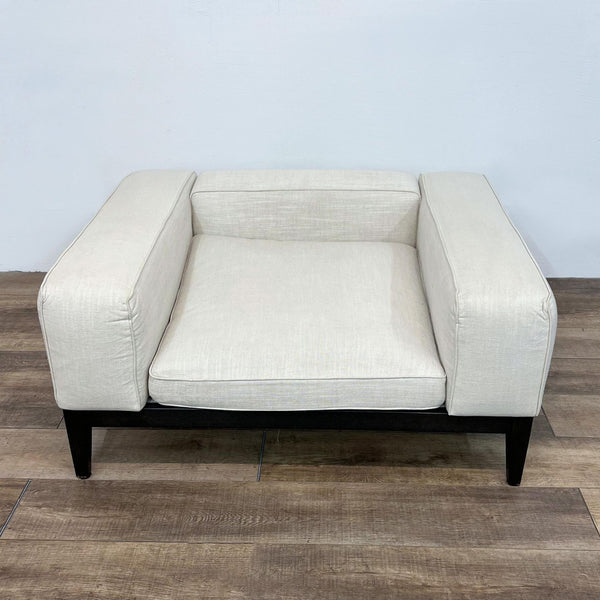 Camerich brand modern beige lounge armchair with cushion on wooden floor against a white wall.