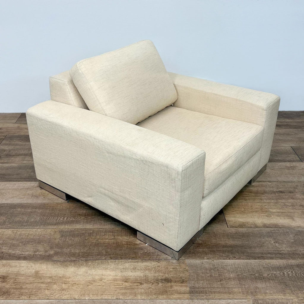 Alt text: Beige Yountville lounge chair by Reperch with block arms, deep seat, angled back, upholstery in performance fabric, resting on chrome block feet.