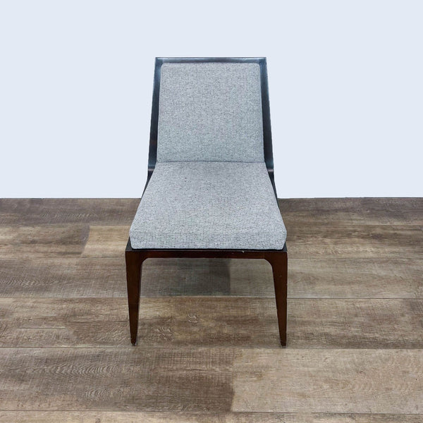 Kimball International dining chair with a sleek design and gray fabric on a wooden floor.