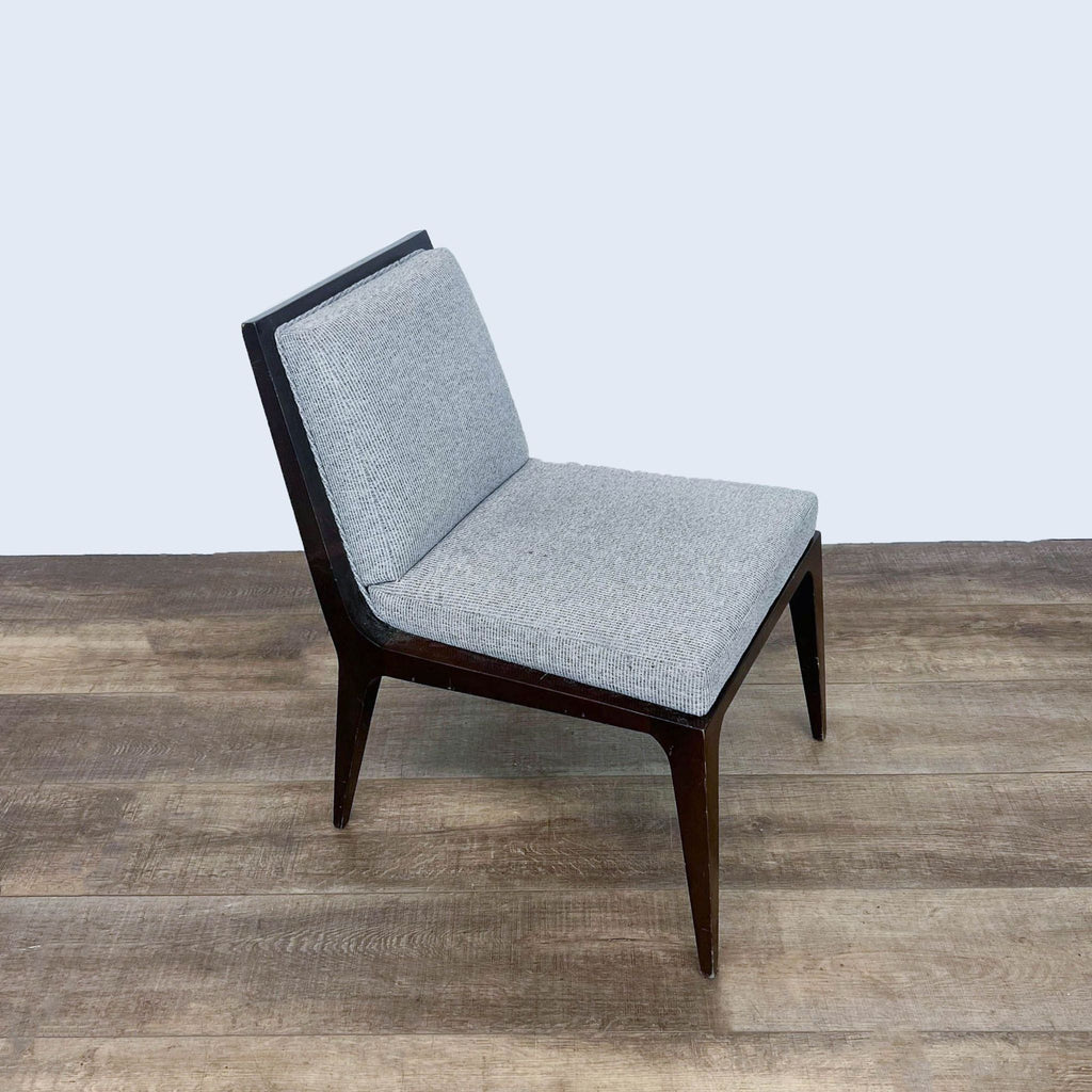 Modern Kimball International chair with gray upholstery and dark wood legs, displayed on a wood-style floor.