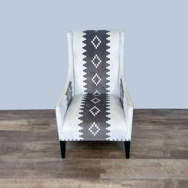 Andrew Martin Pluto chair, high-backed with western print fabric and nailhead trim, profile view on a wooden floor.