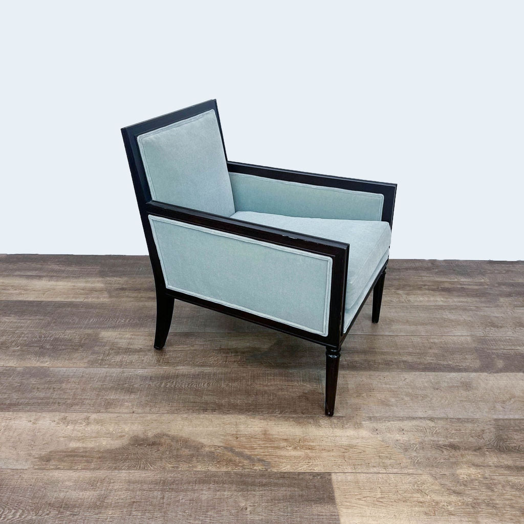 Side angle of a Reperch transitional armchair featuring light blue velvet fabric and a sleek black wooden frame.