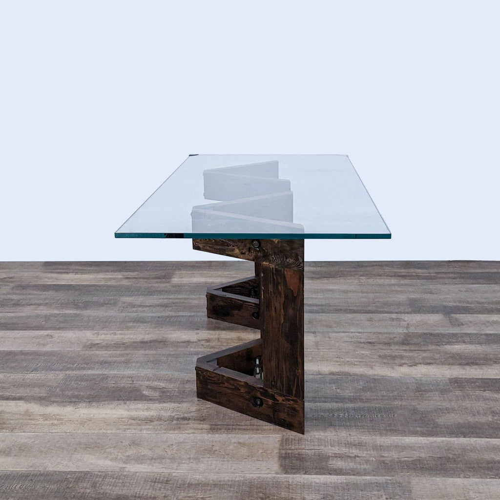 Thomas Bina designed coffee table featuring a V-shaped reclaimed wood base and a thick, clear tempered glass top with metal details.