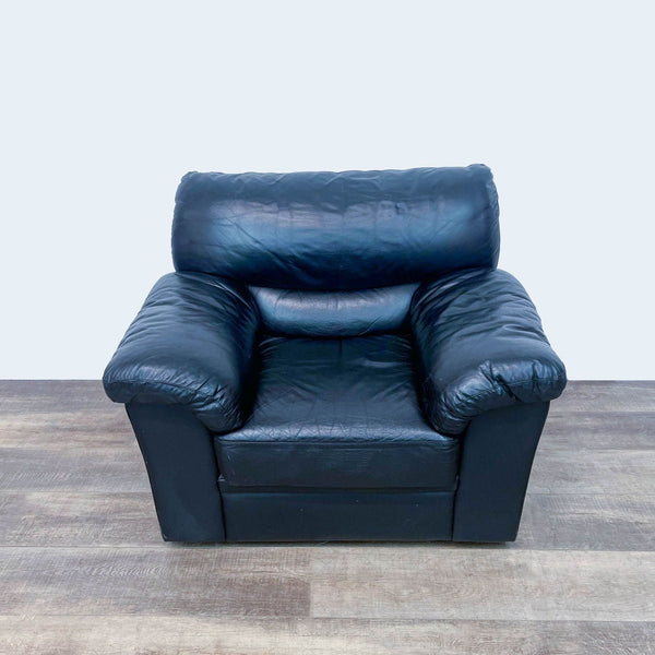 Reperch brand black leather armchair in a lounge setting, frontal view.