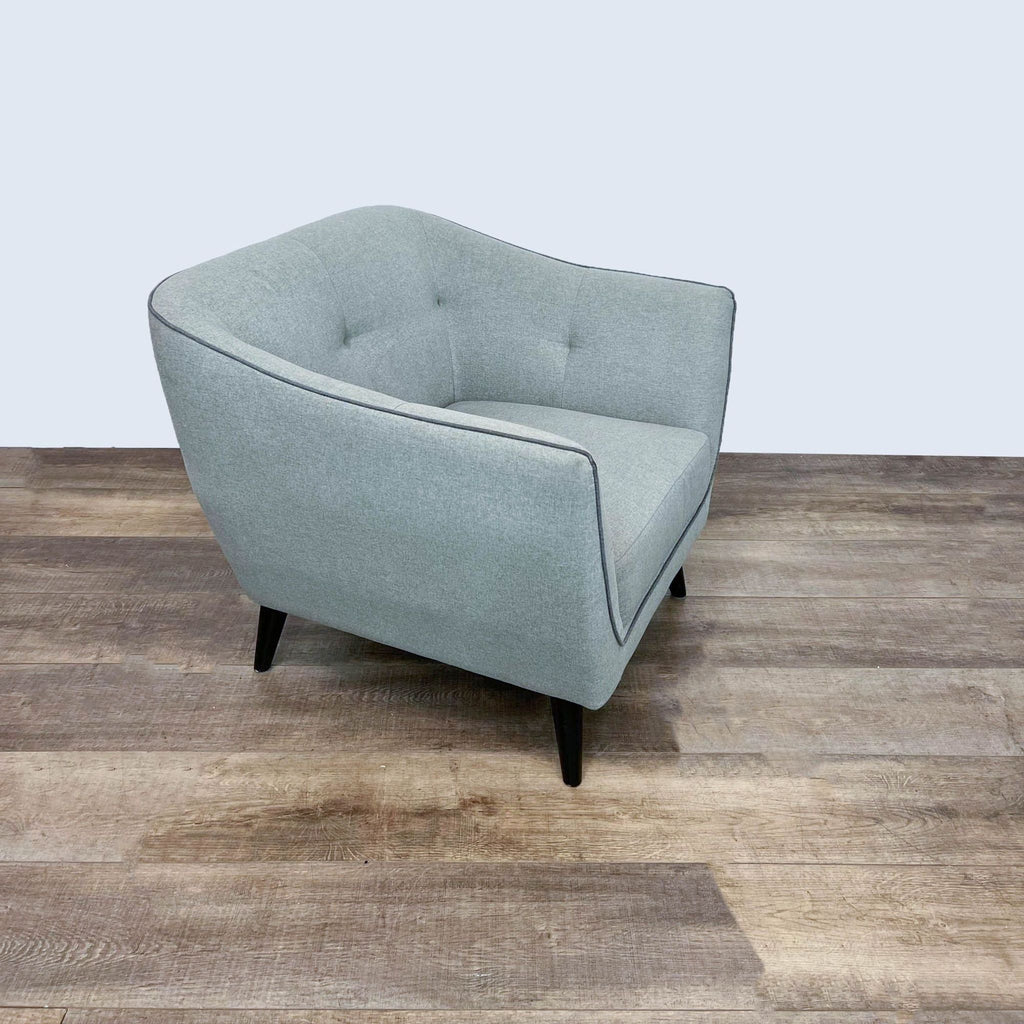 Gray Ace Interior lounge chair with mid-century design, tufted backrest, and contrasting welt trim.