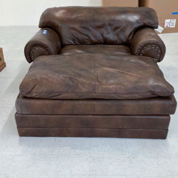 Reperch oversized brown leather chaise lounge with plush cushioning and rolled arms featuring nailhead trim.