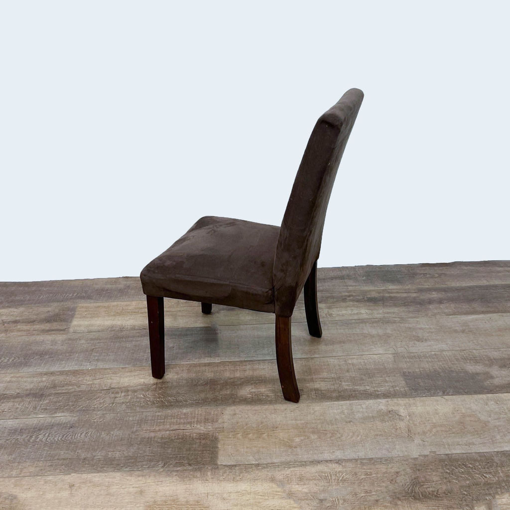 Side angle of a Reperch lounge chair with soft brown upholstery and dark wood legs.