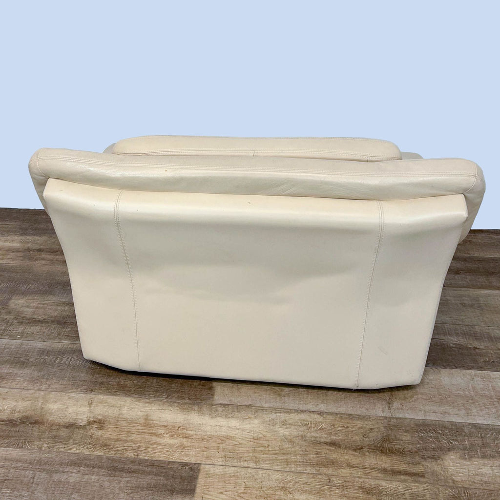 Contemporary Reperch brand lounge chair featuring cream leather upholstery and wide armrests with wooden feet, on a wooden floor.