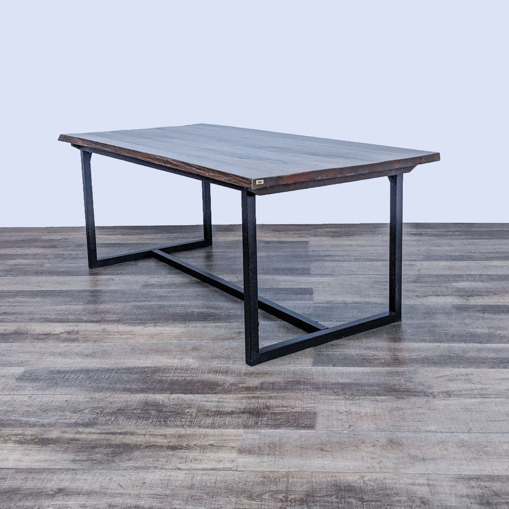 Rectangular distressed cherry oak tabletop on a sleek black metal base, by Zuo Era, viewed at an angle.