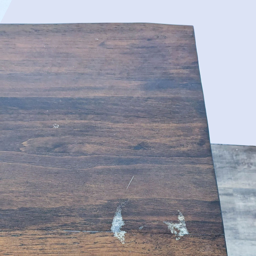 Close-up of Zuo Era Industrial dining table's distressed cherry oak finish showing wood texture and edge detail.