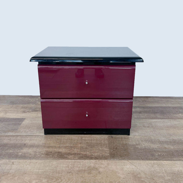 Alt text 1: Millennium brand end table with a black top and burgundy body featuring two closed drawers, set against a wood floor.