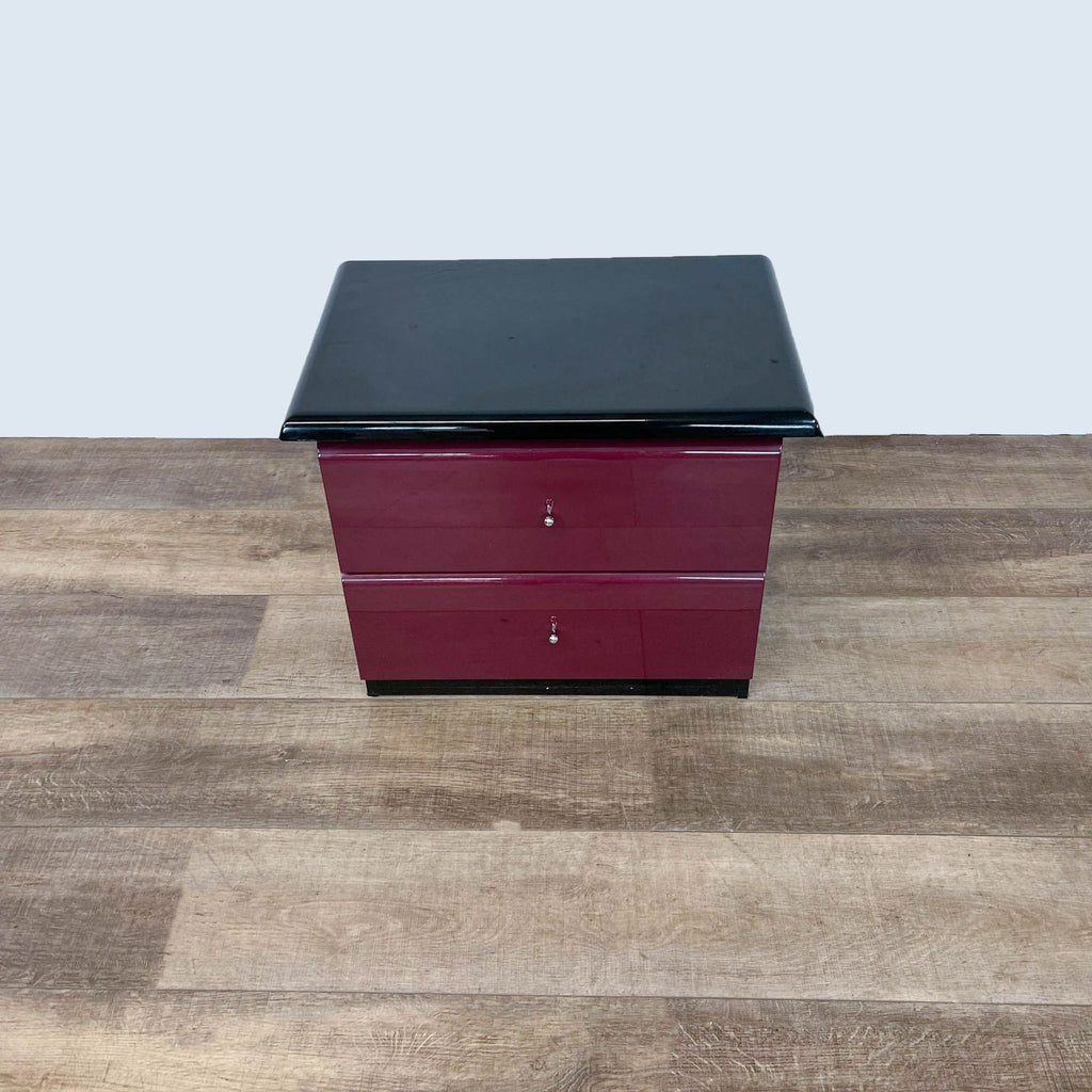 Millennium brand dark top end table with two burgundy drawers on a wooden floor.