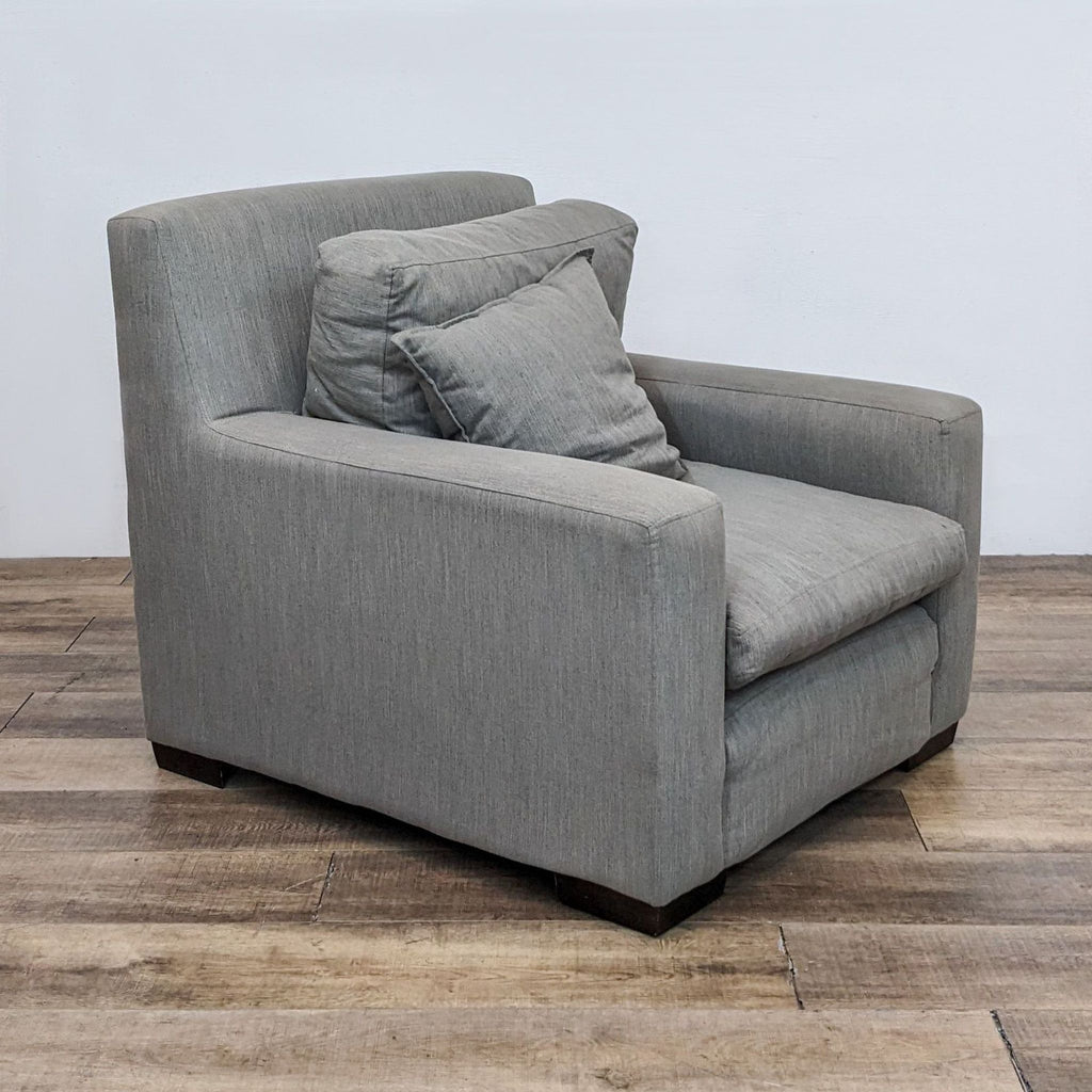 Reperch brand contemporary gray upholstered lounge chair with removable cushions and a throw pillow, on a wooden floor.