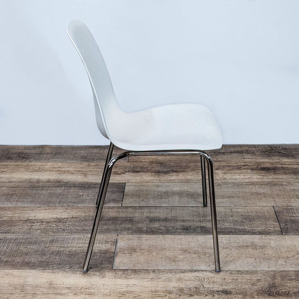 Front-facing view of an IKEA Broringe dining chair highlighting its contemporary white polypropylene ergonomic seat and chrome base.