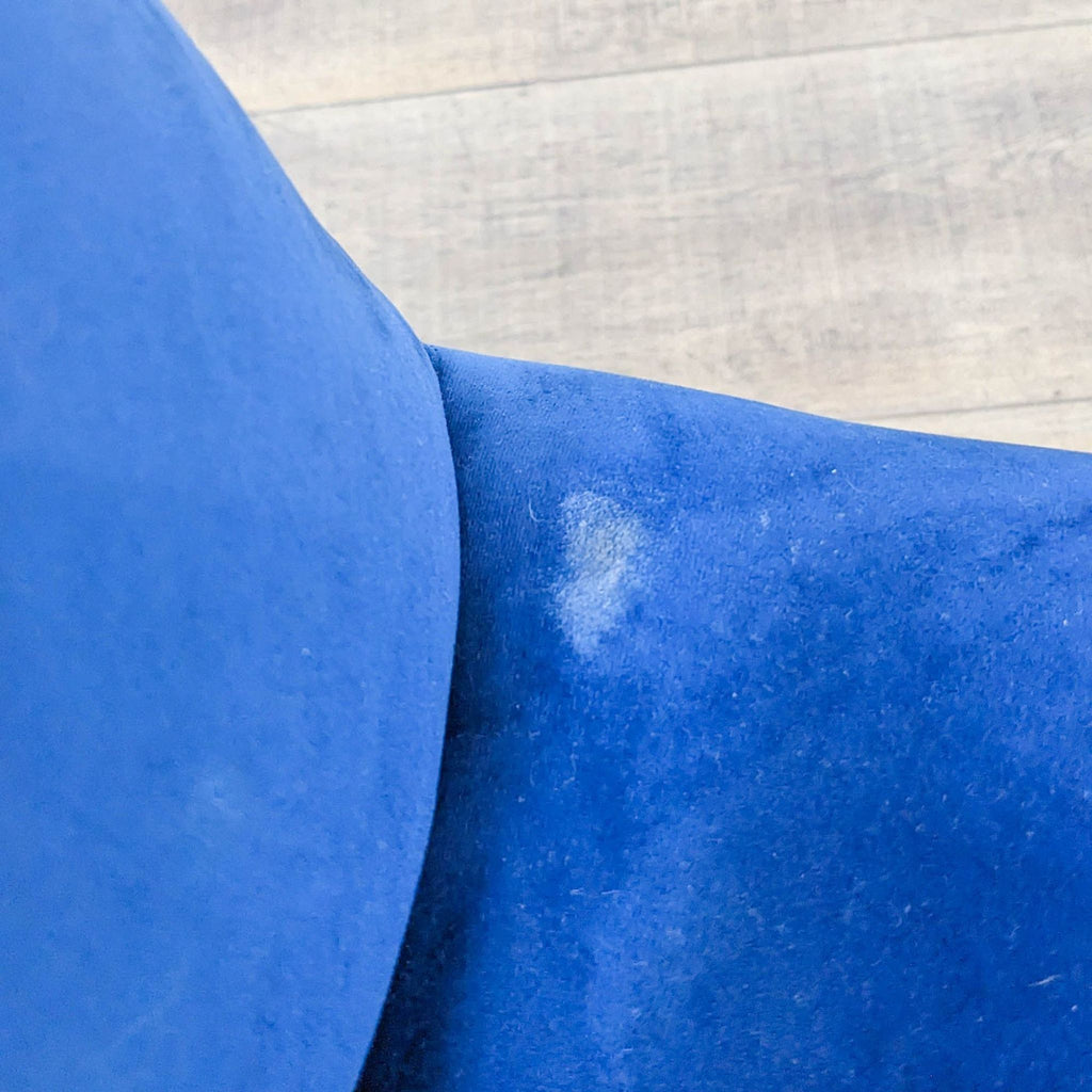 Close-up of a Wayfair tufted blue velvet cushion showing texture and a small stain.