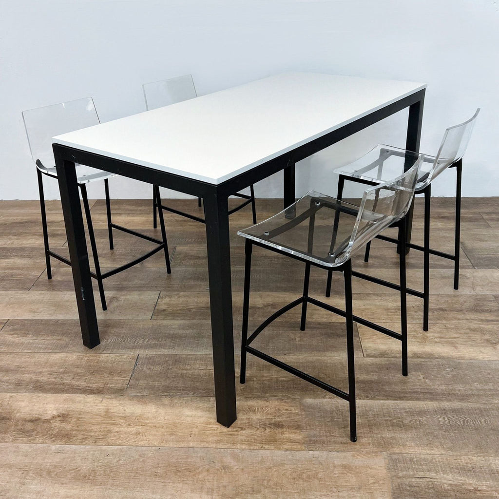 Modern dining set featuring a white quartz-topped steel base table and four stools with clear acrylic seats and black steel legs, by Room & Board and CB2.