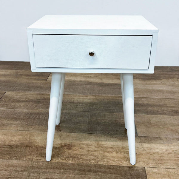 White Reperch end table with single drawer and round knob on wooden floor.