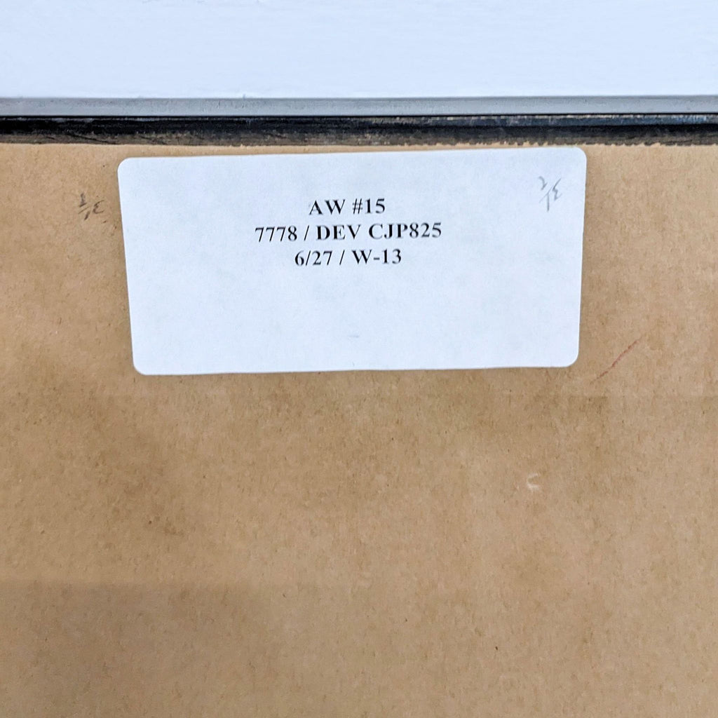 Label on the back of framed artwork with identification numbers and dates.