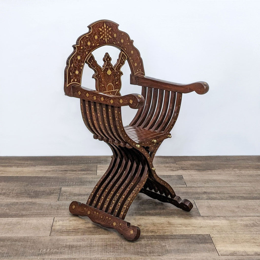 Reperch Savonarola chair with ornate brass inlay, foldable design on wooden floor.