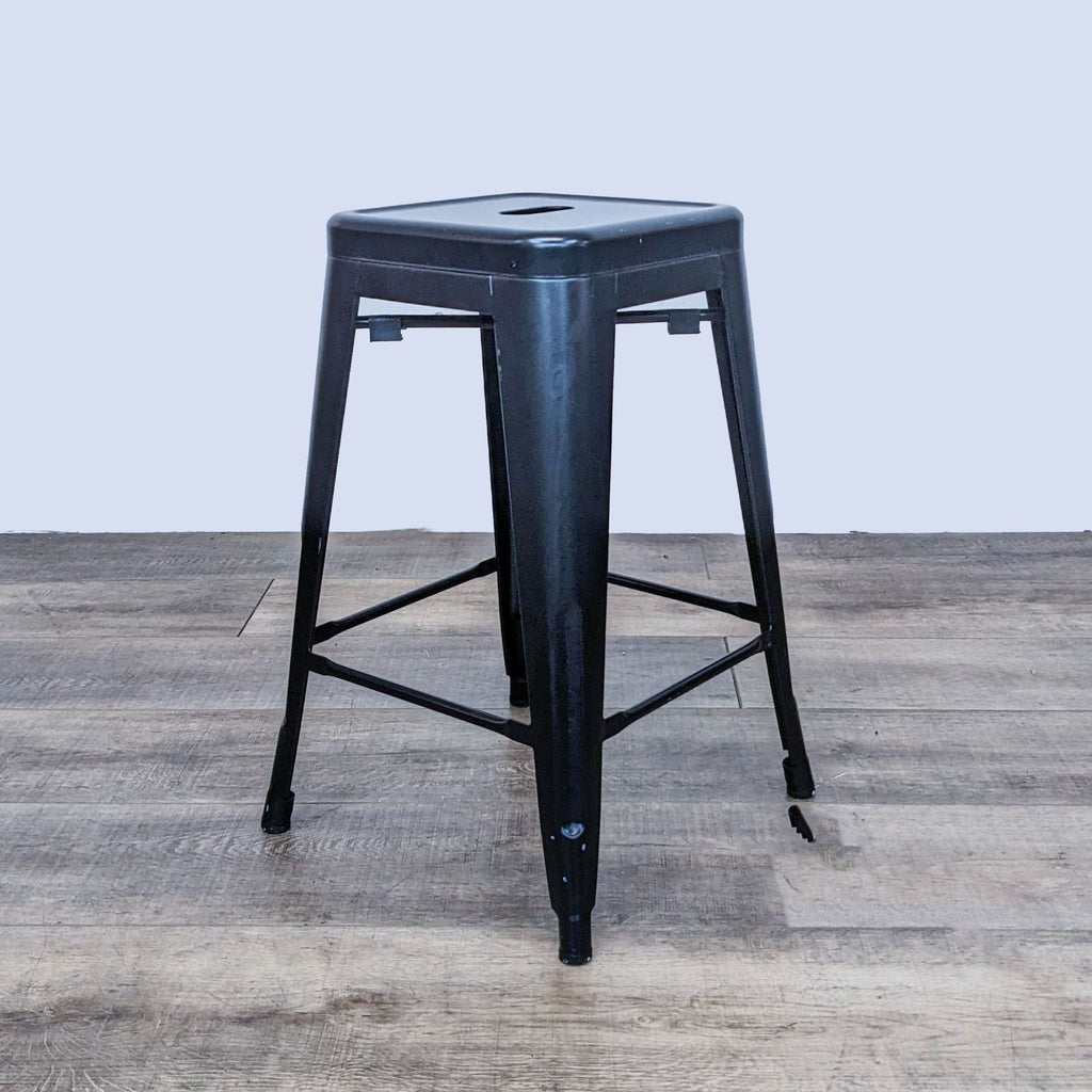 Black square-top stool by Reperch, with hole detail, shown in profile view.