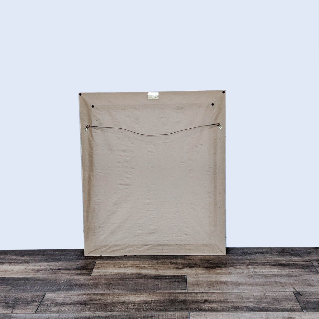 Back view of an Art & Frame Co. classic wall mirror with a covered dark wooden frame on a wooden floor.