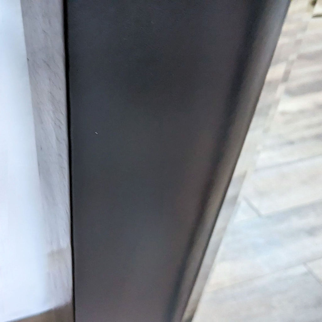 Close-up of the Reperch mirror's leather-wrapped frame detailing and texture.
