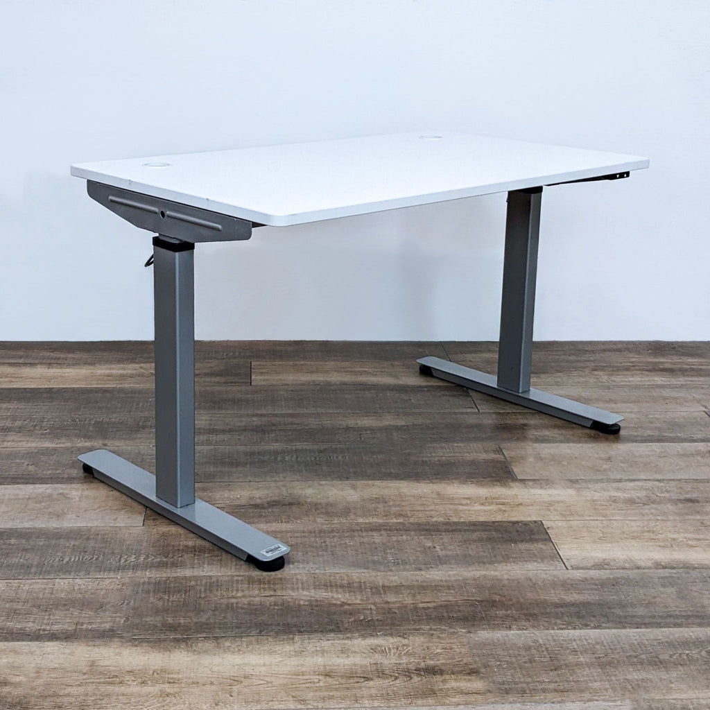 Alt text: Reperch brand motorized adjustable desk with a white top and gray steel frame, showcased on wooden flooring.