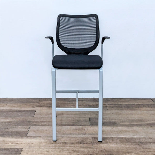 HON brand modern barstool with black stretch mesh back and durable steel frame against a wooden floor.