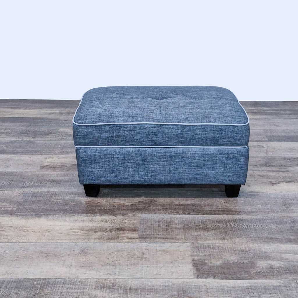 Alt text 2: Closed view of a Laurel Foundry dark grey fabric ottoman with button tufting detail and dark finish feet.