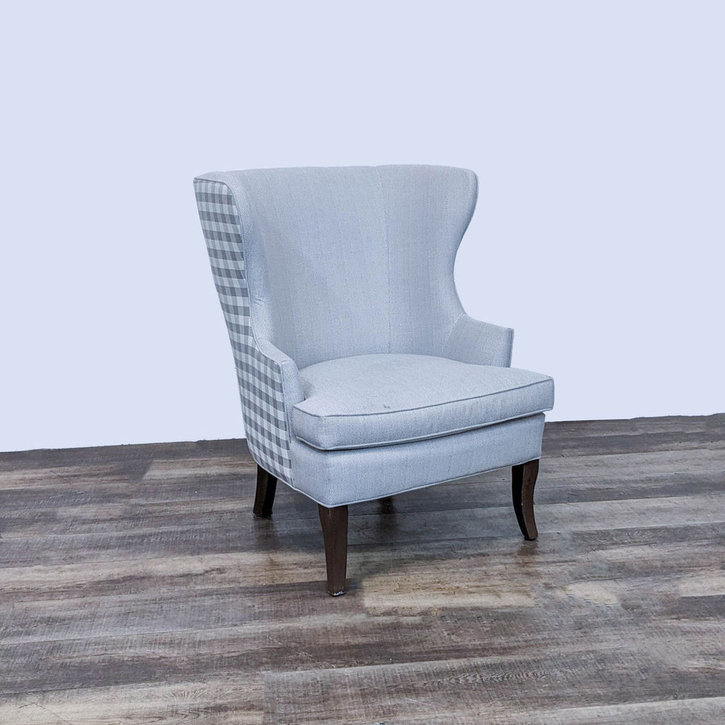 3. Ballard Designs wingback chair featuring a mix of neutral fabric and Buffalo plaid, showcasing its modern design.