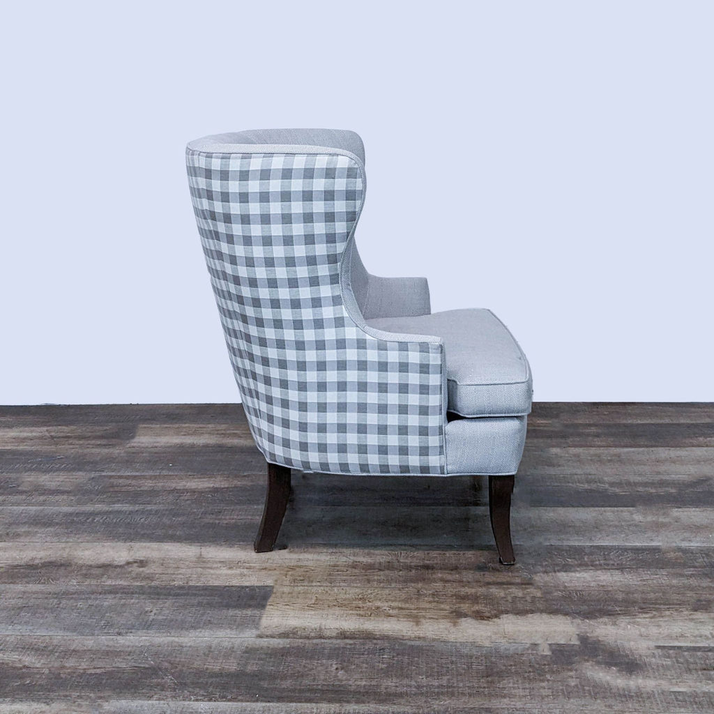 2. Side view of a Ballard Designs chair showing the Buffalo plaid design on the back, with curved lines and neutral seat.