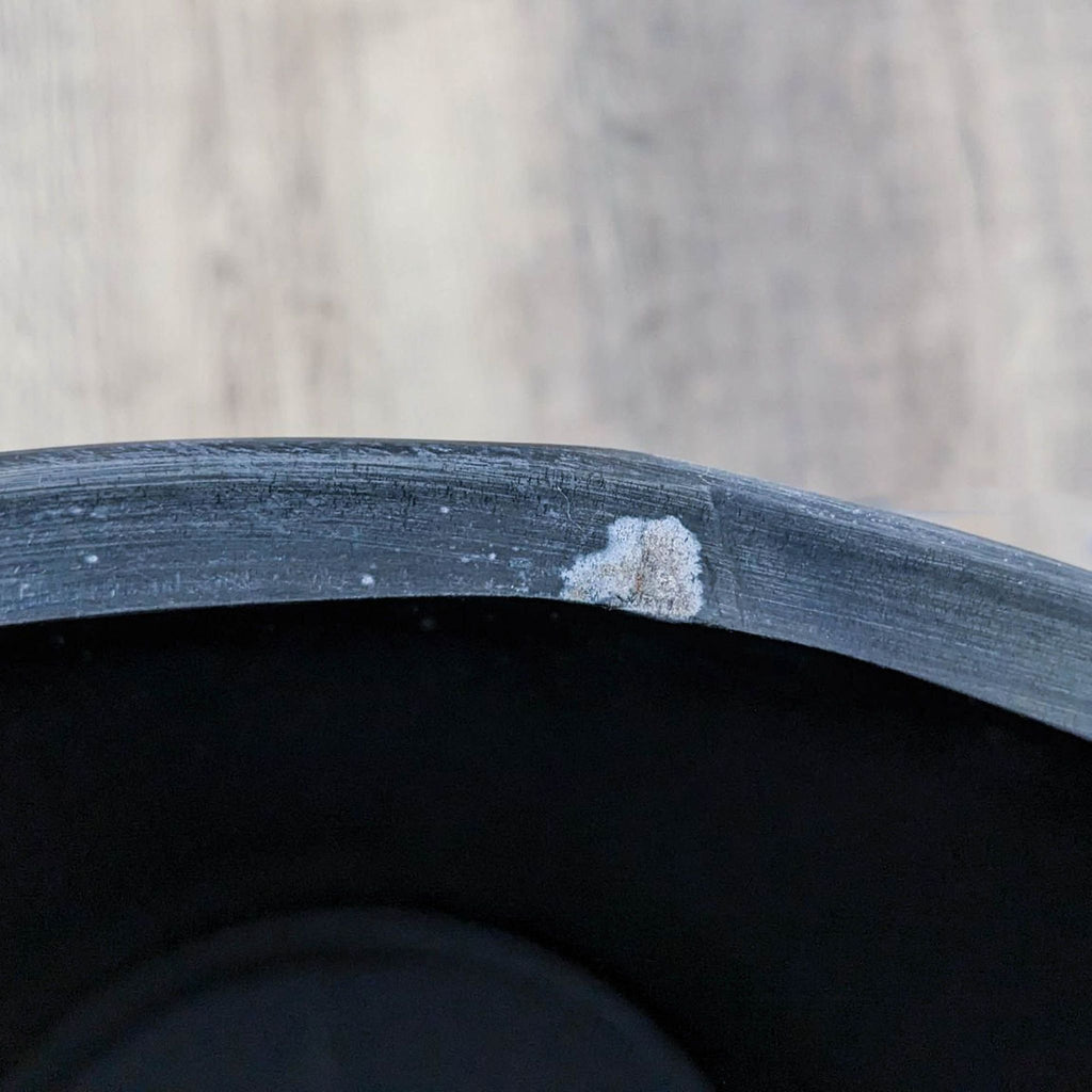 Close-up of a Reperch drum table edge showing wear and chipping paint.