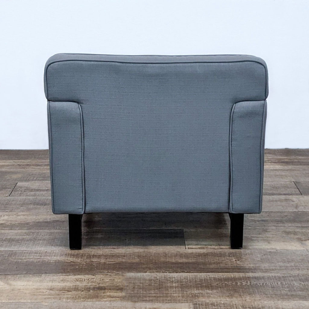 Reperch modern lounge chair in gray fabric, showcasing squared off arm rests and tufted back, rear view.