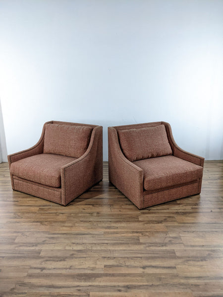 Pair of Reperch lounge chairs in terracotta fabric on wooden flooring.