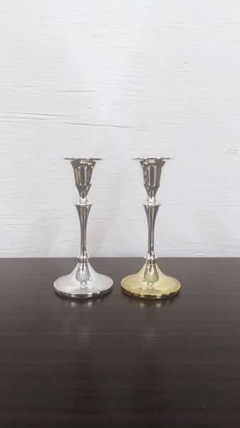 Alt text 1: Two Reperch brand candlesticks on a table, one silver and one gold-toned, with elegant designs.