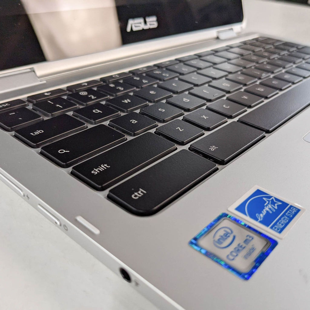 Close-up of an Asus laptop keyboard focusing on Intel Core i3 sticker.