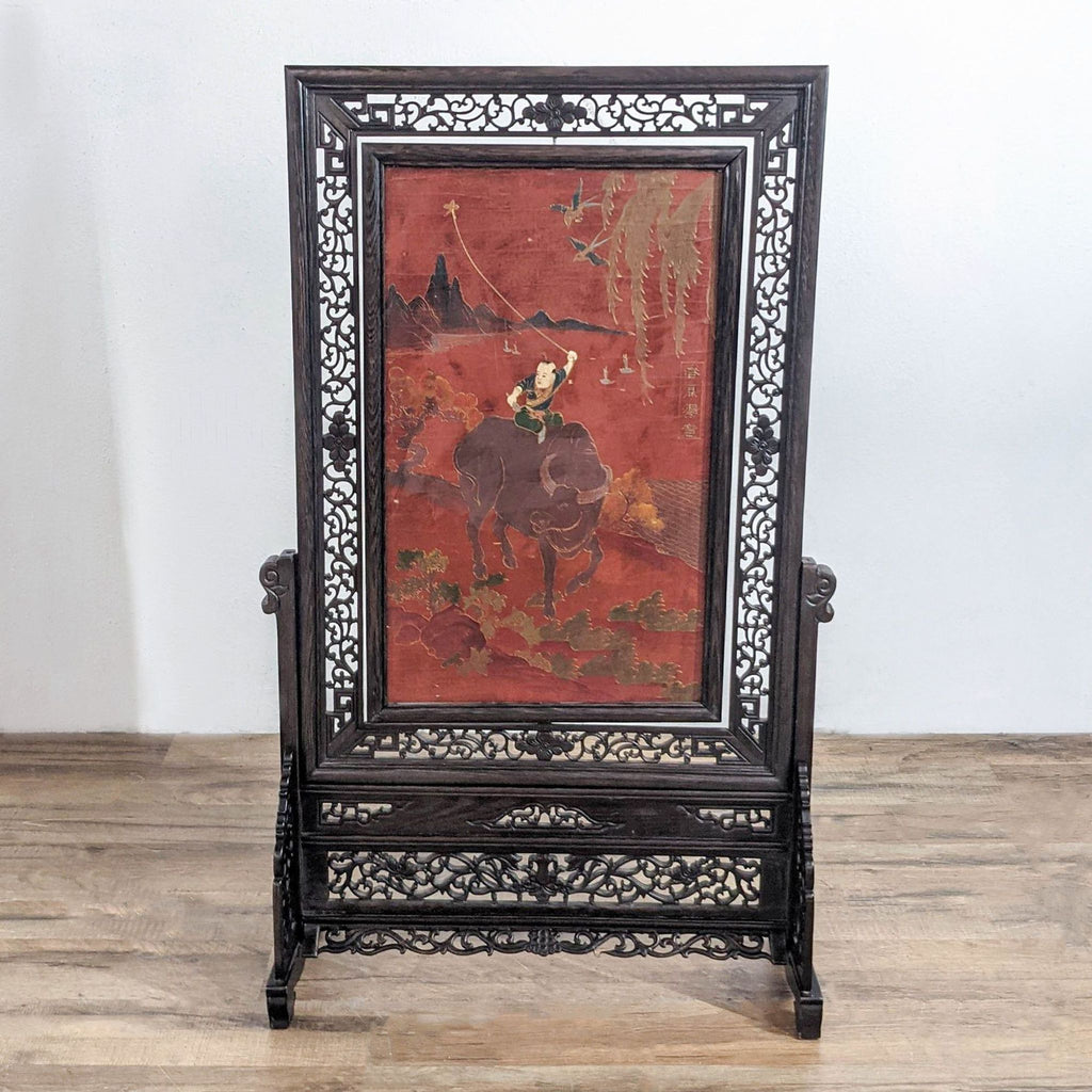 2. Reperch standing frame displaying artwork of a child on an animal, with detailed carved wood border.